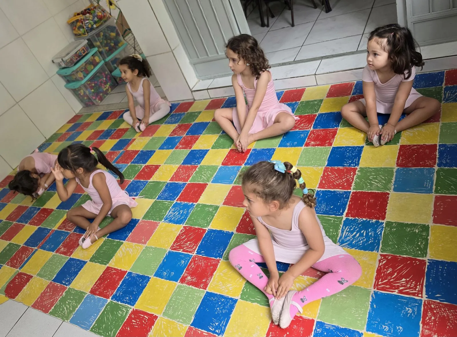 Turma da aula de balé sentada em roda no tatame colorido da Escola Lapidar